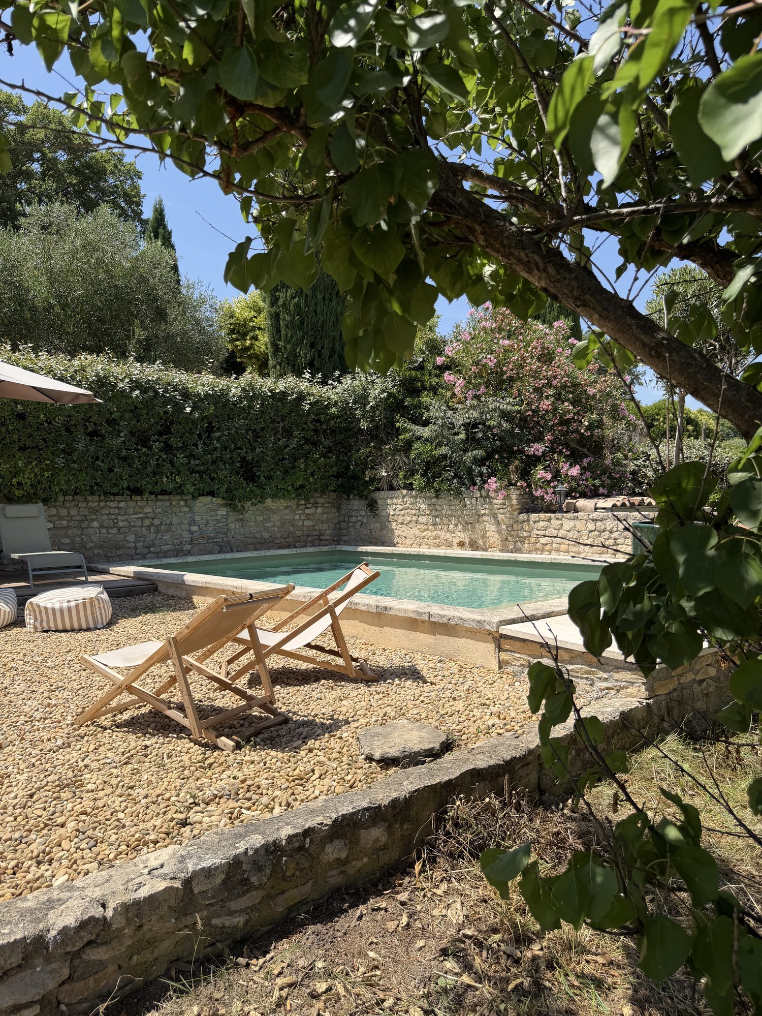 Coin détente ombragé au bord de la piscine