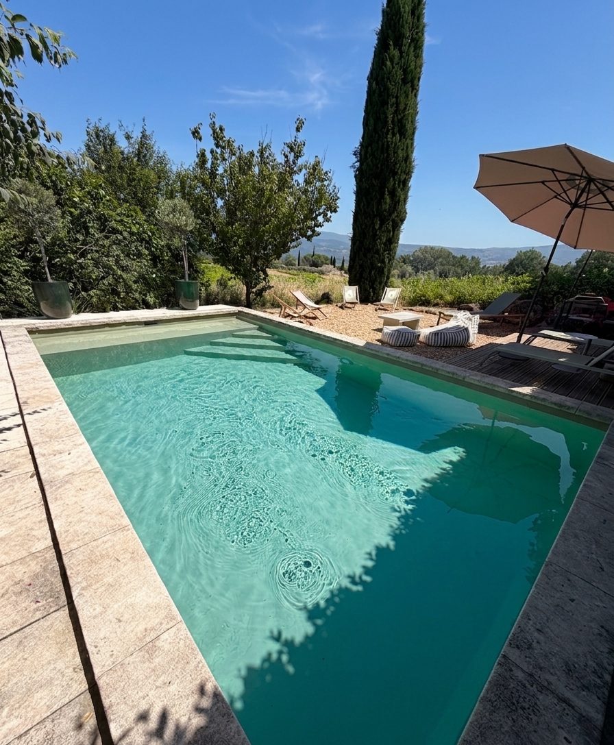 Piscine et cyprès face aux vignes du Luberon